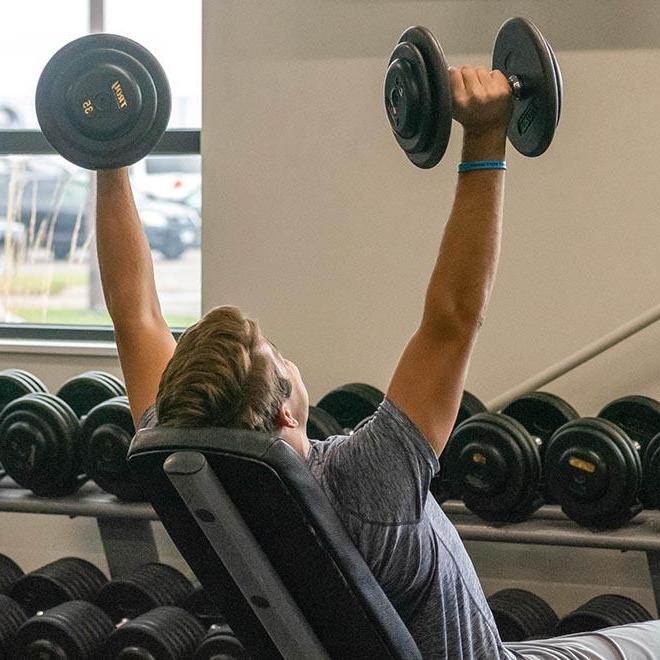 Student lifting weights in the fitness center.